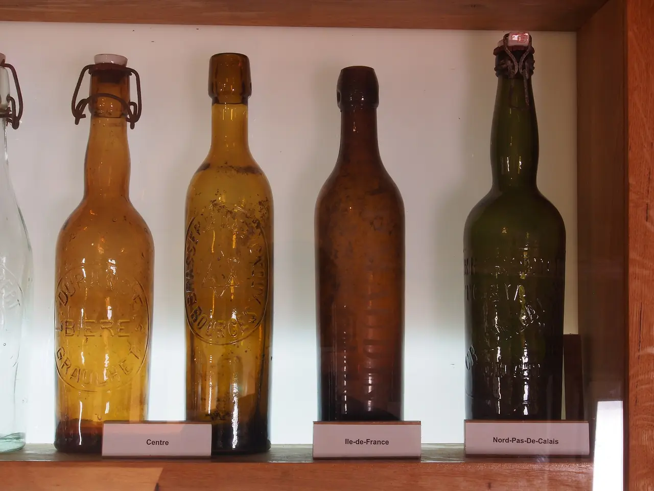 Old amber and green beer bottles on a shelf