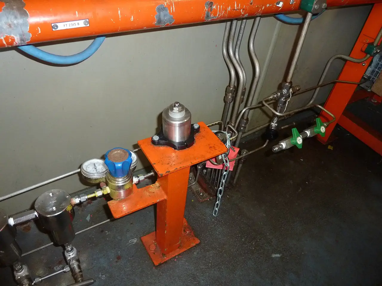 Gas pressure regulator with gauges and pipes on an orange stand