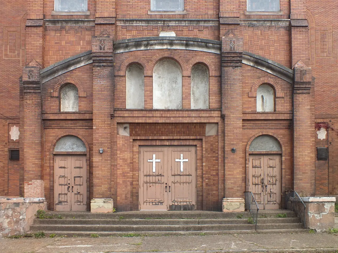 Red brick church front with double wooden doors and steps