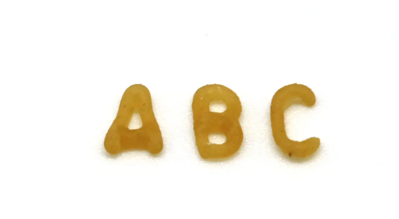 Three alphabet pasta pieces spelling A B C on white