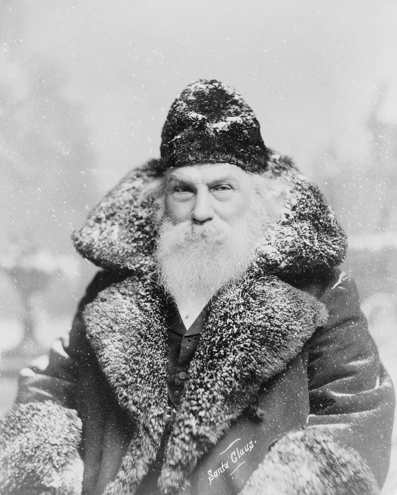 A bearded man in a fur coat and hat as Santa Claus