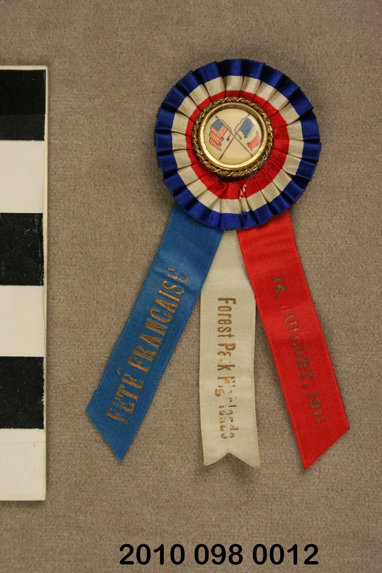 A red, white and blue rosette with three hanging ribbons