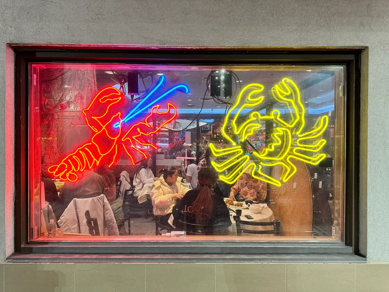 Red lobster and yellow crab neon sign in a window