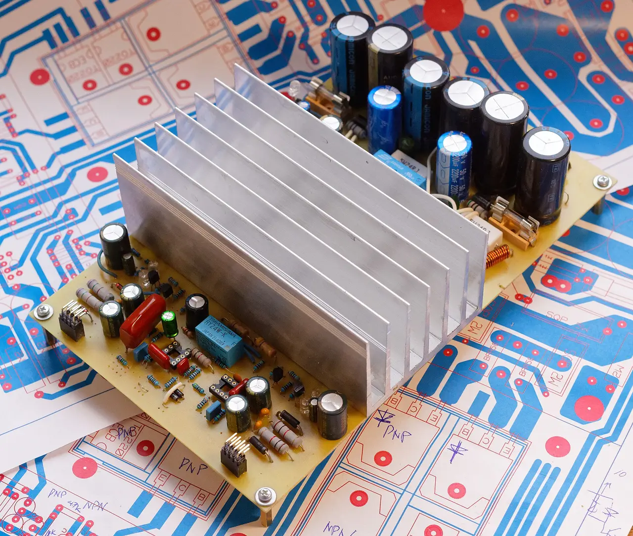 Amplifier circuit board with aluminium heat sink and capacitors