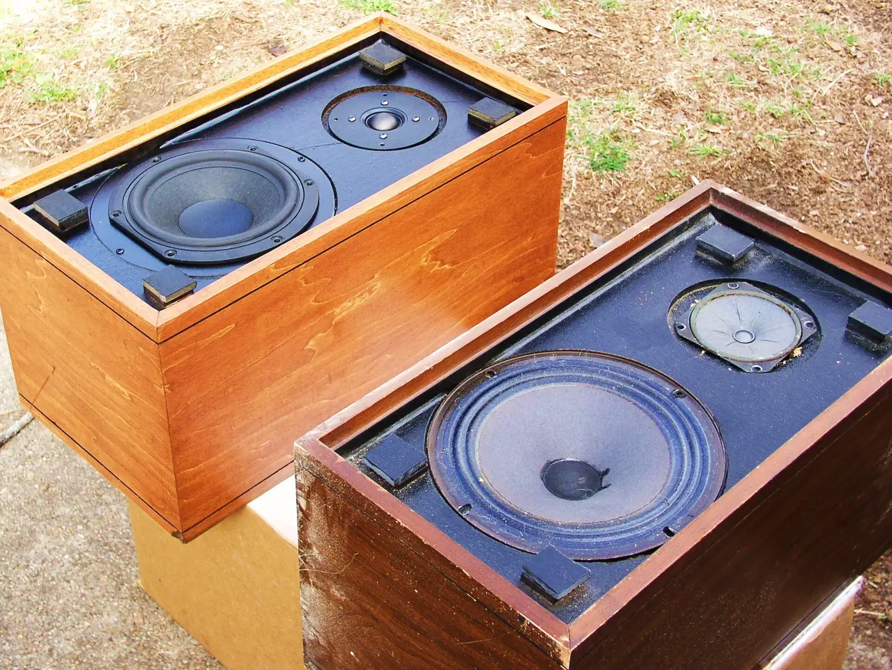 Two wooden speaker cabinets with the cones showing