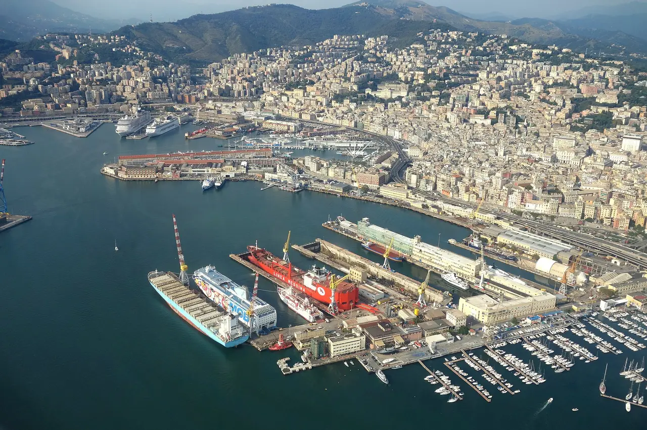 Aerial view of ships moored in Genoa harbour below a hillside city