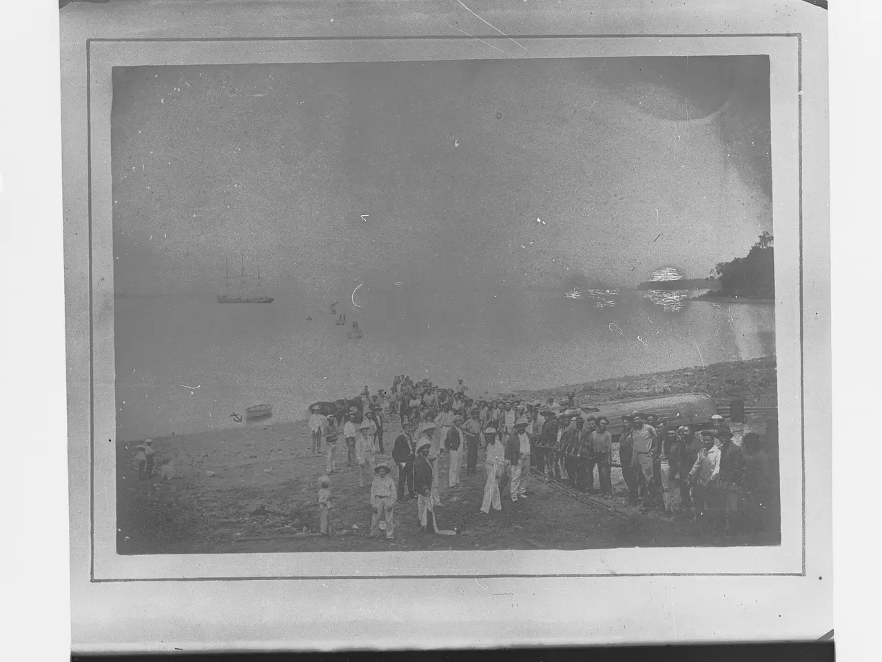 A crowd gathered on a beach as a cable is landed