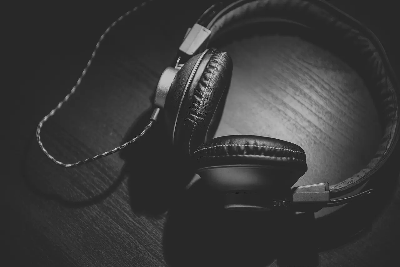 Black and white photo of over-ear headphones on wood