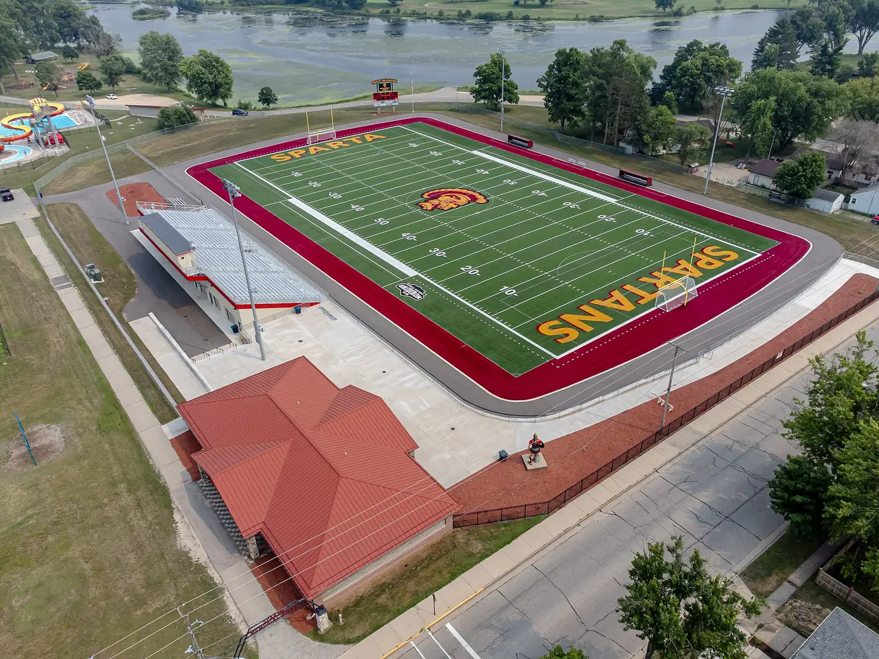 Aerial view of a green football field with a red track