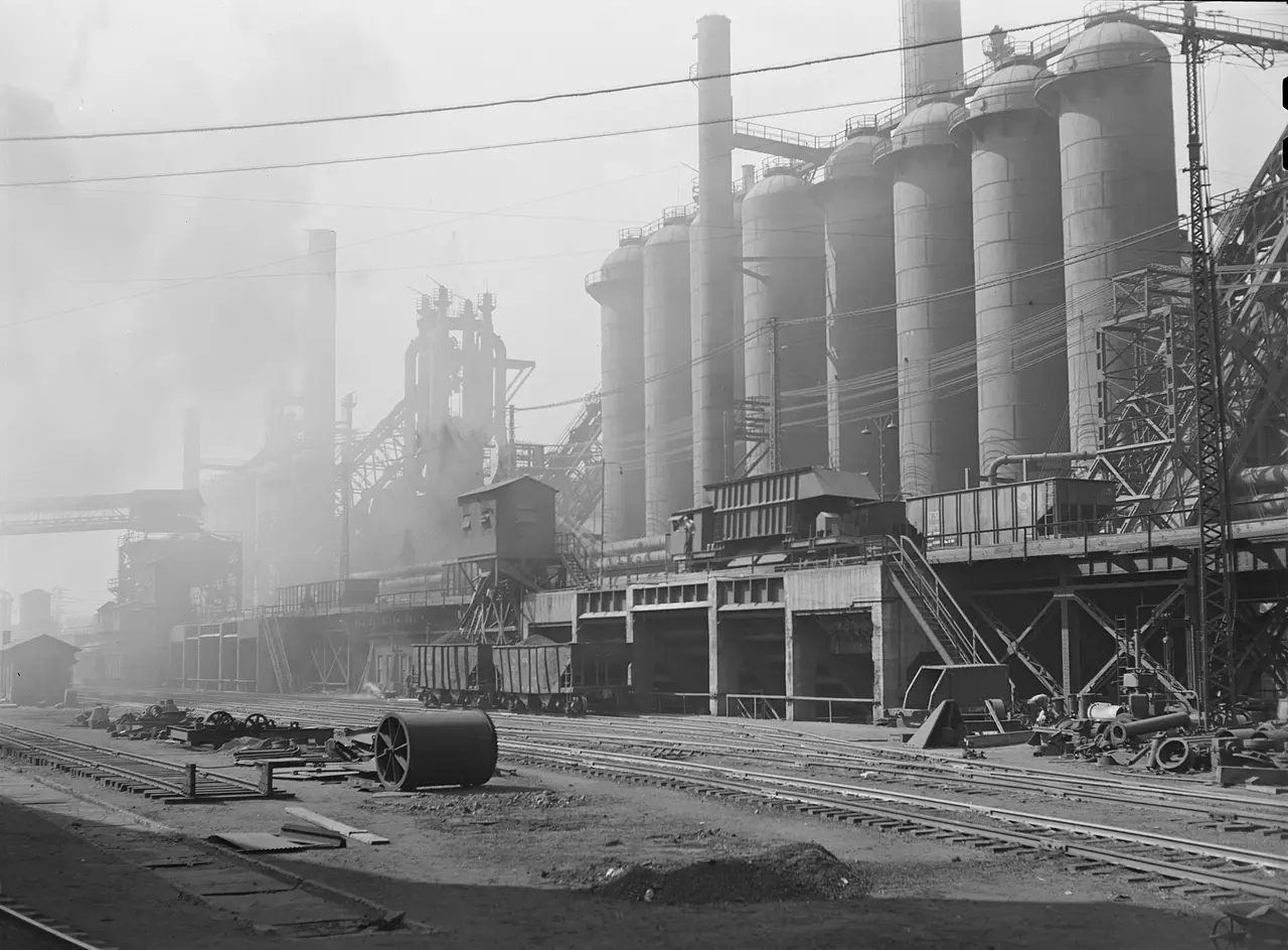 Black and white view of blast furnaces and smoke at a steel mill
