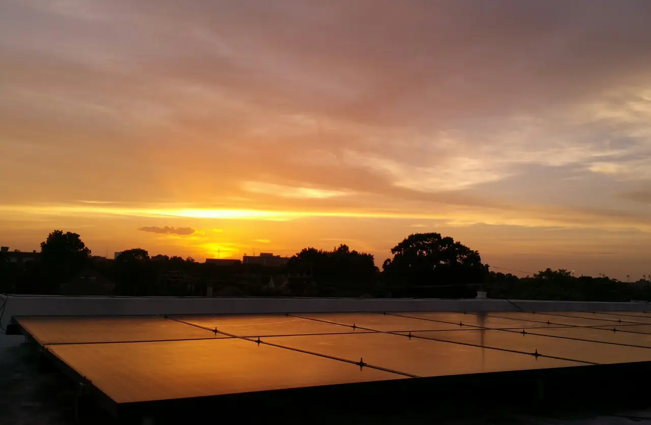 Solar panels reflecting an orange sunset sky