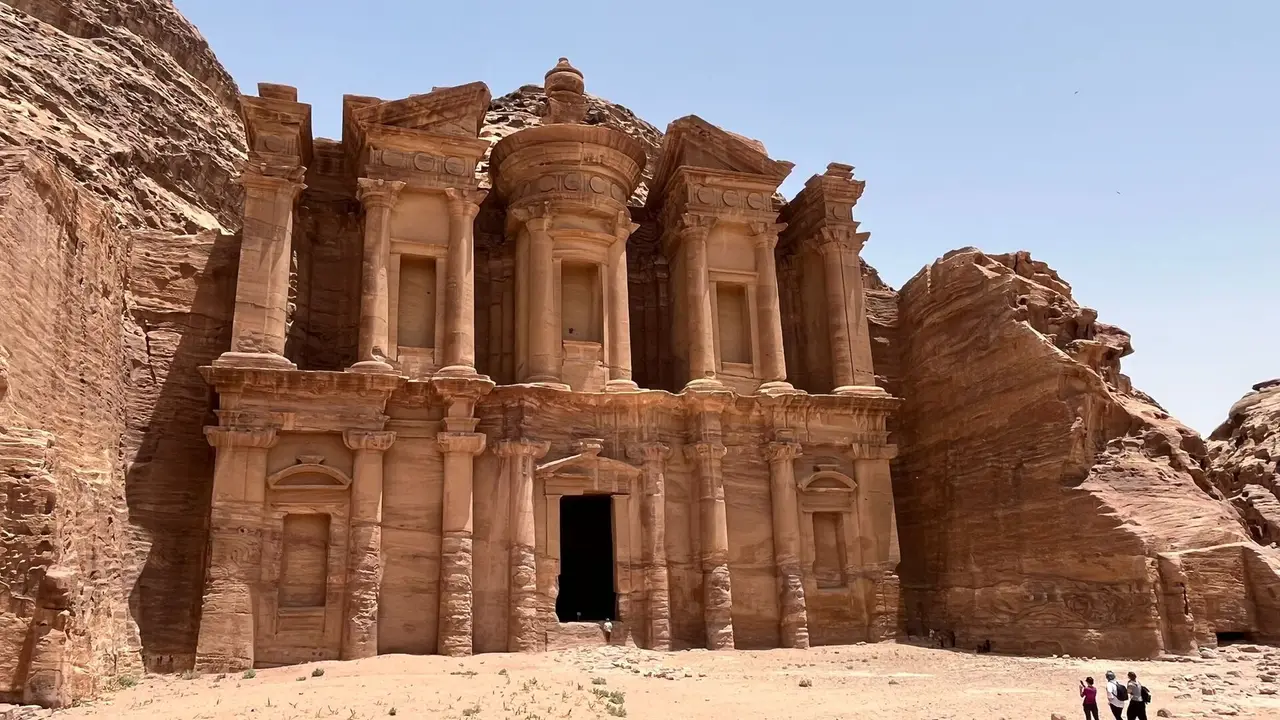 A tall carved sandstone temple facade under a blue sky