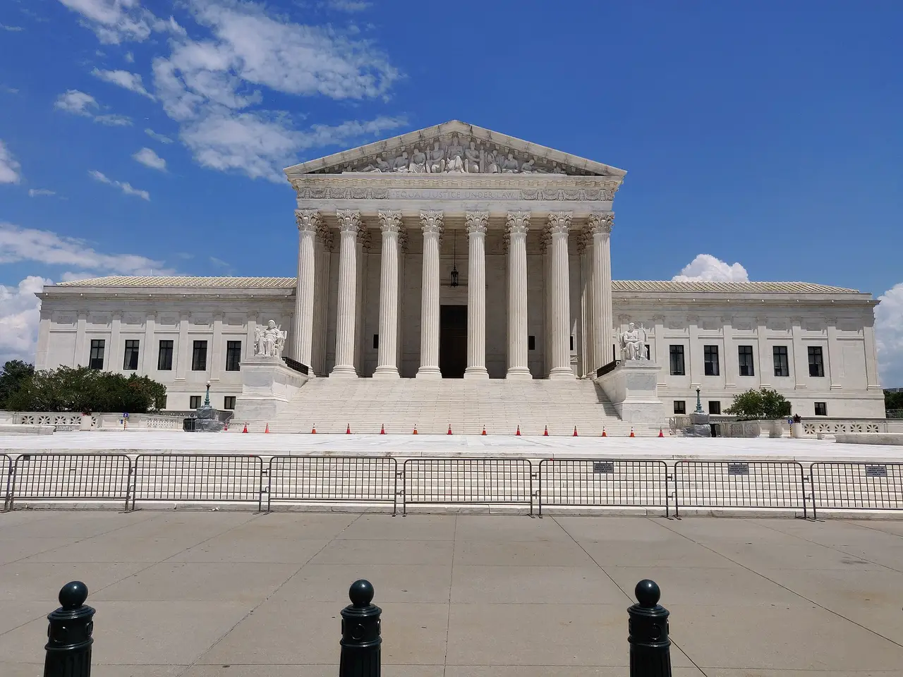 A white marble courthouse with columns under a blue sky
