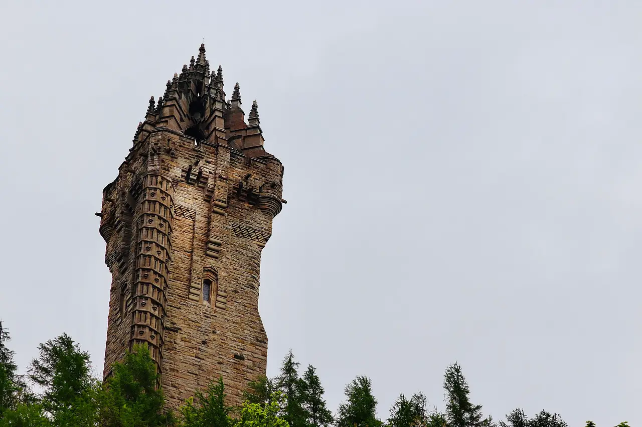 A tall stone tower with pointed pinnacles against a grey sky