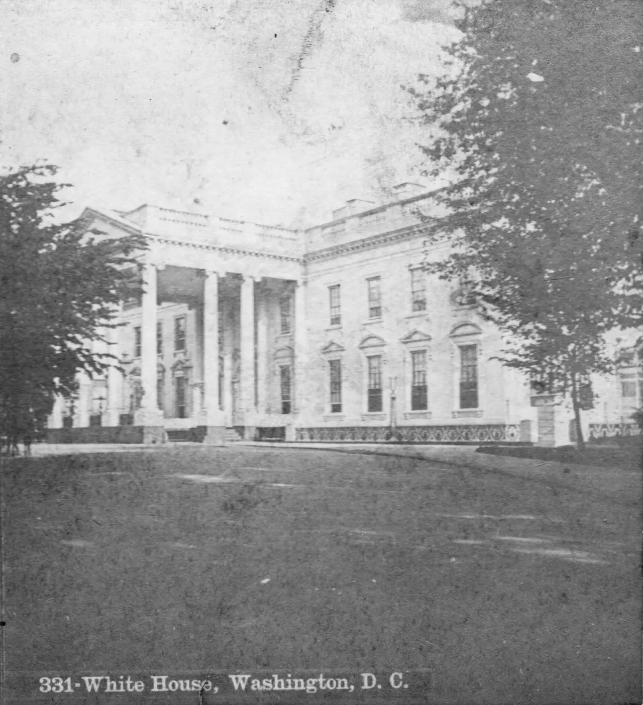 Old black and white photograph of the White House and its lawn