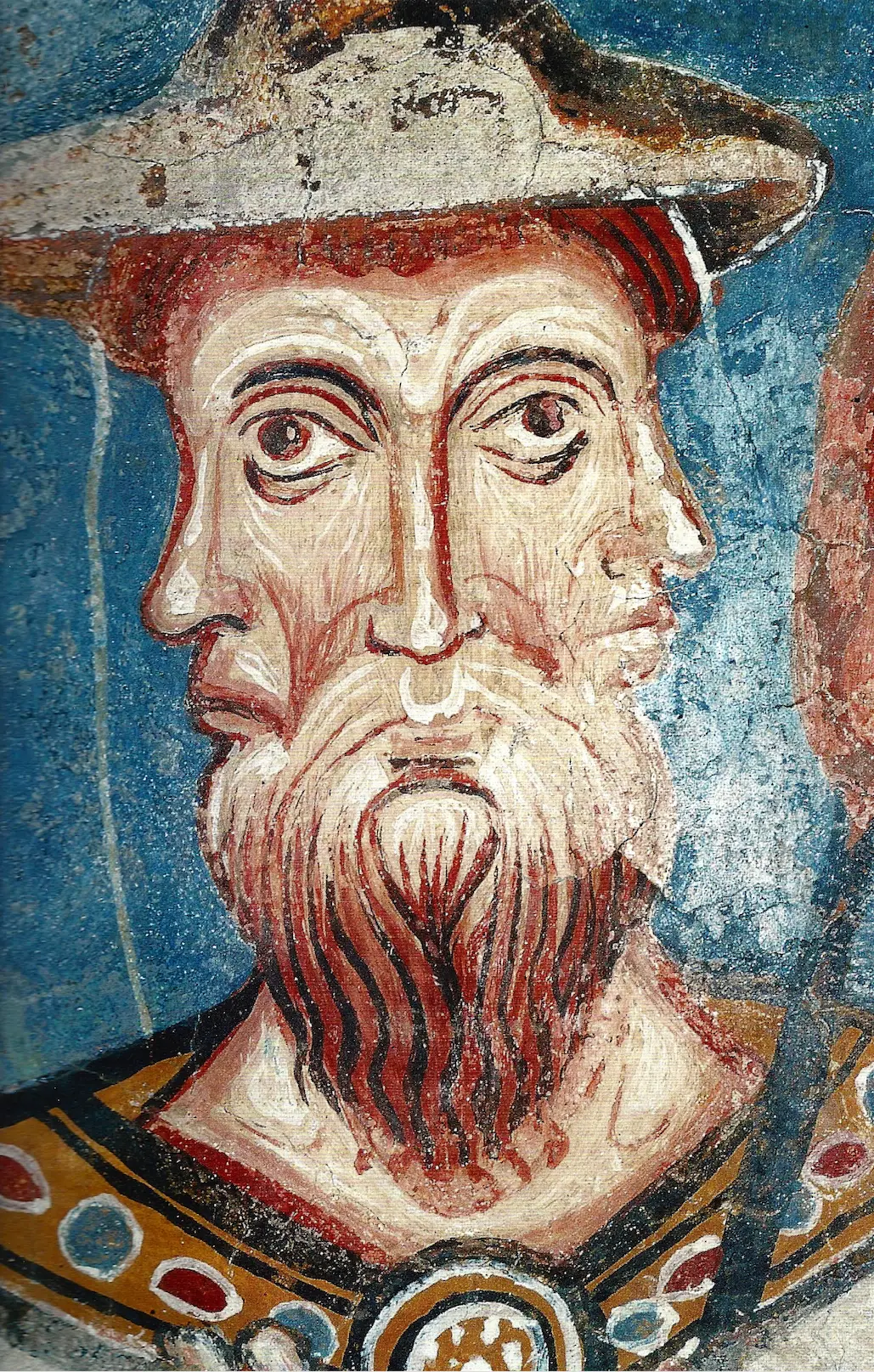 A fresco of a two-faced bearded man in a hat