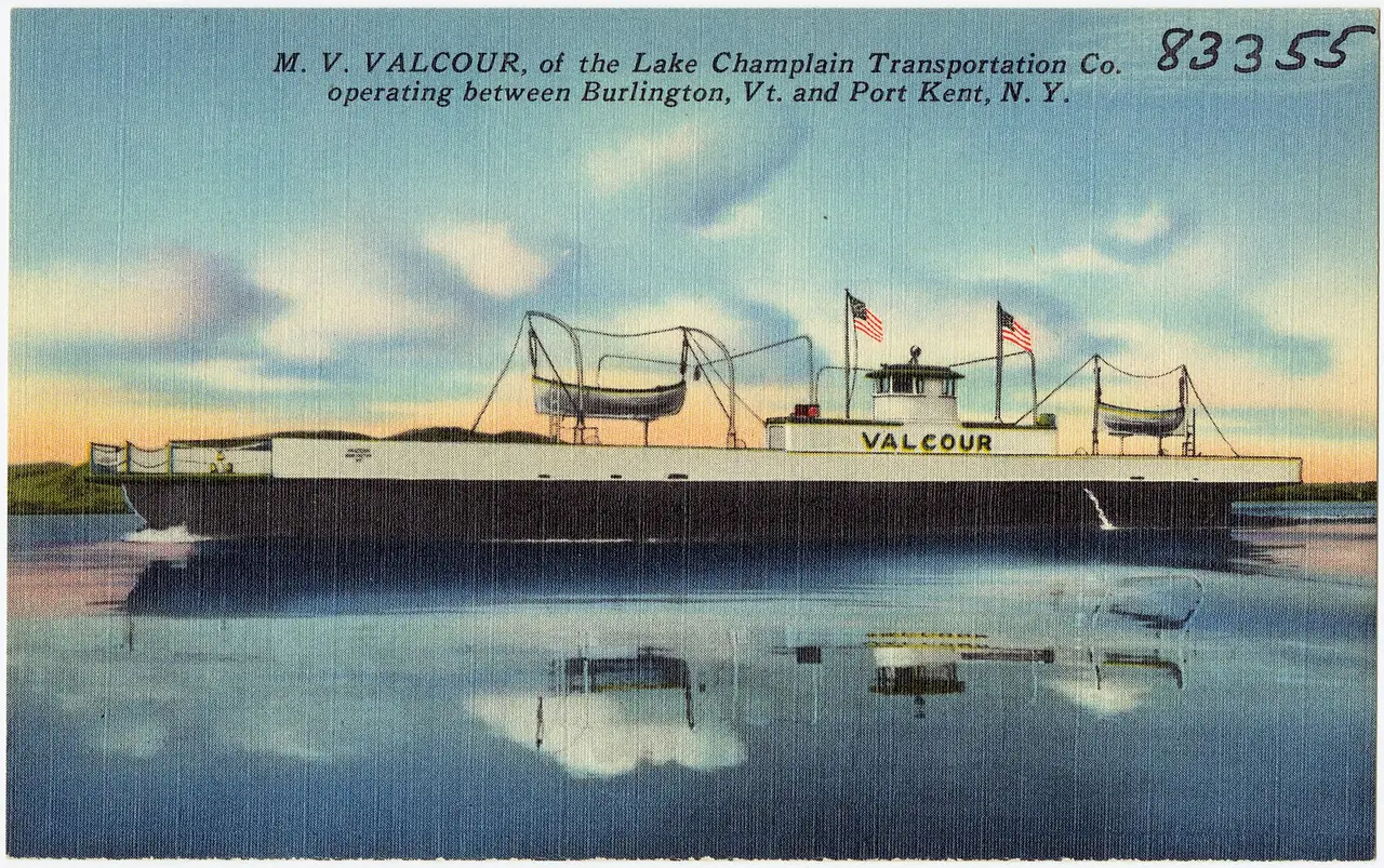 A white car ferry crossing calm water with a reflection