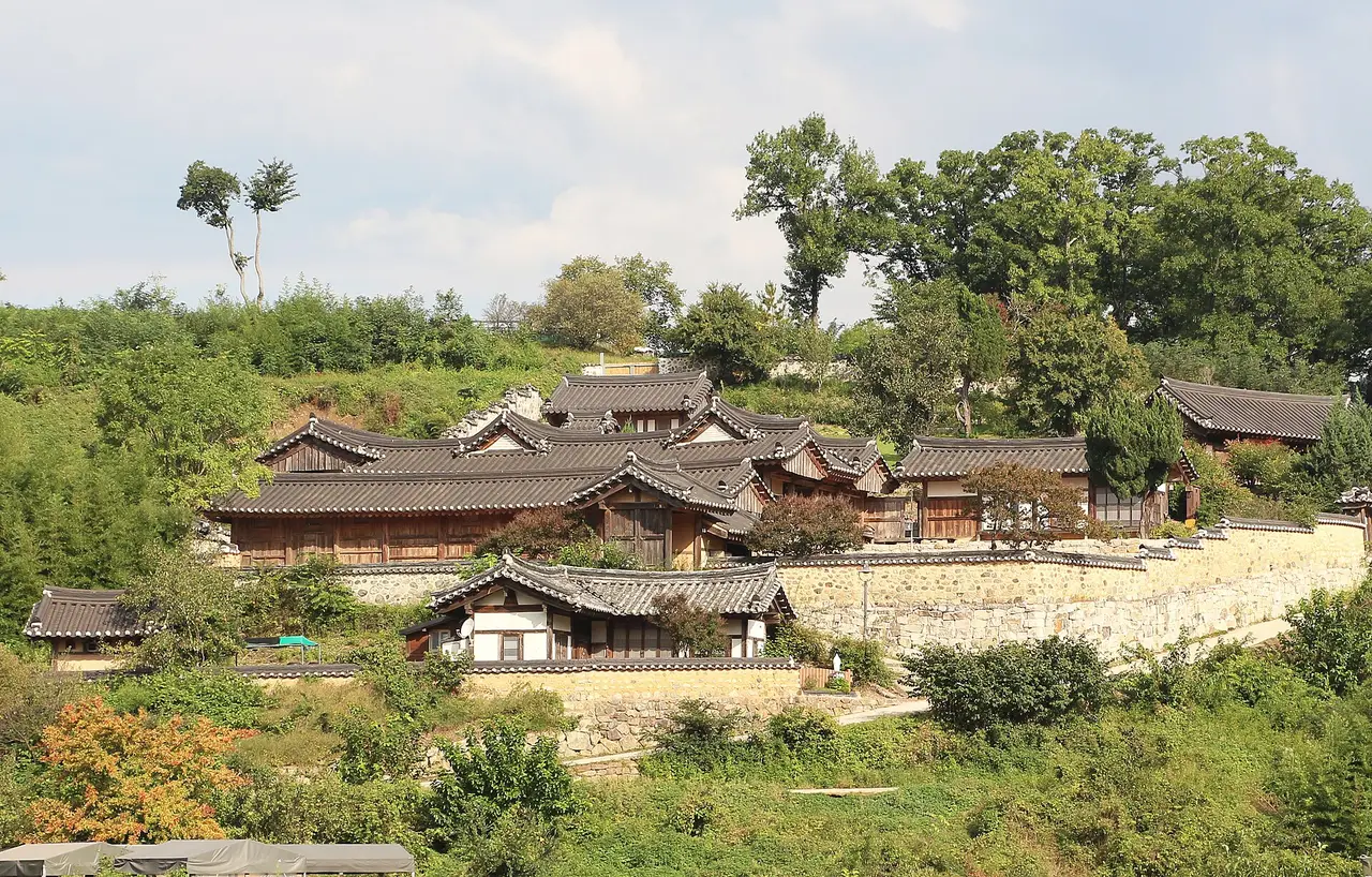 Traditional village houses among green trees on a hillside