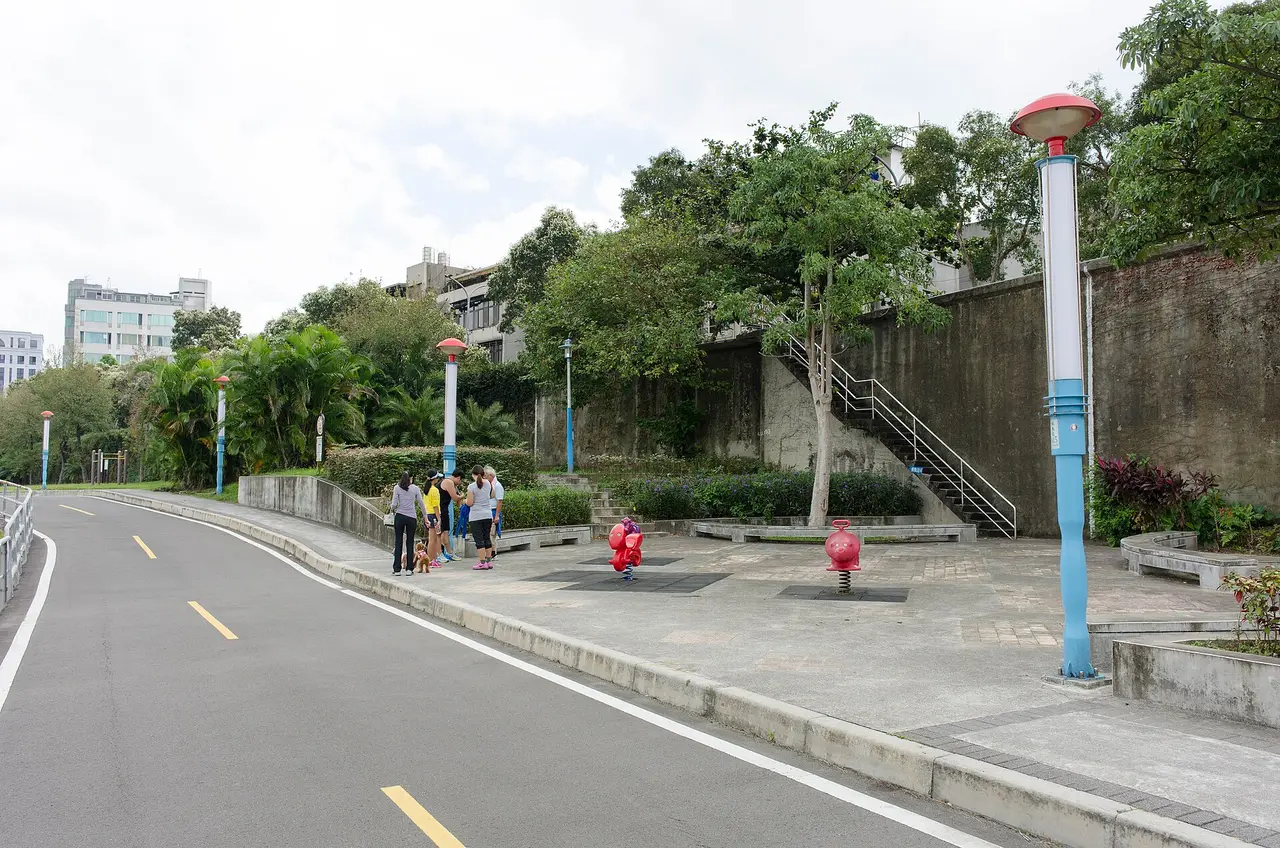 Small groups of people chatting beside a quiet road with trees