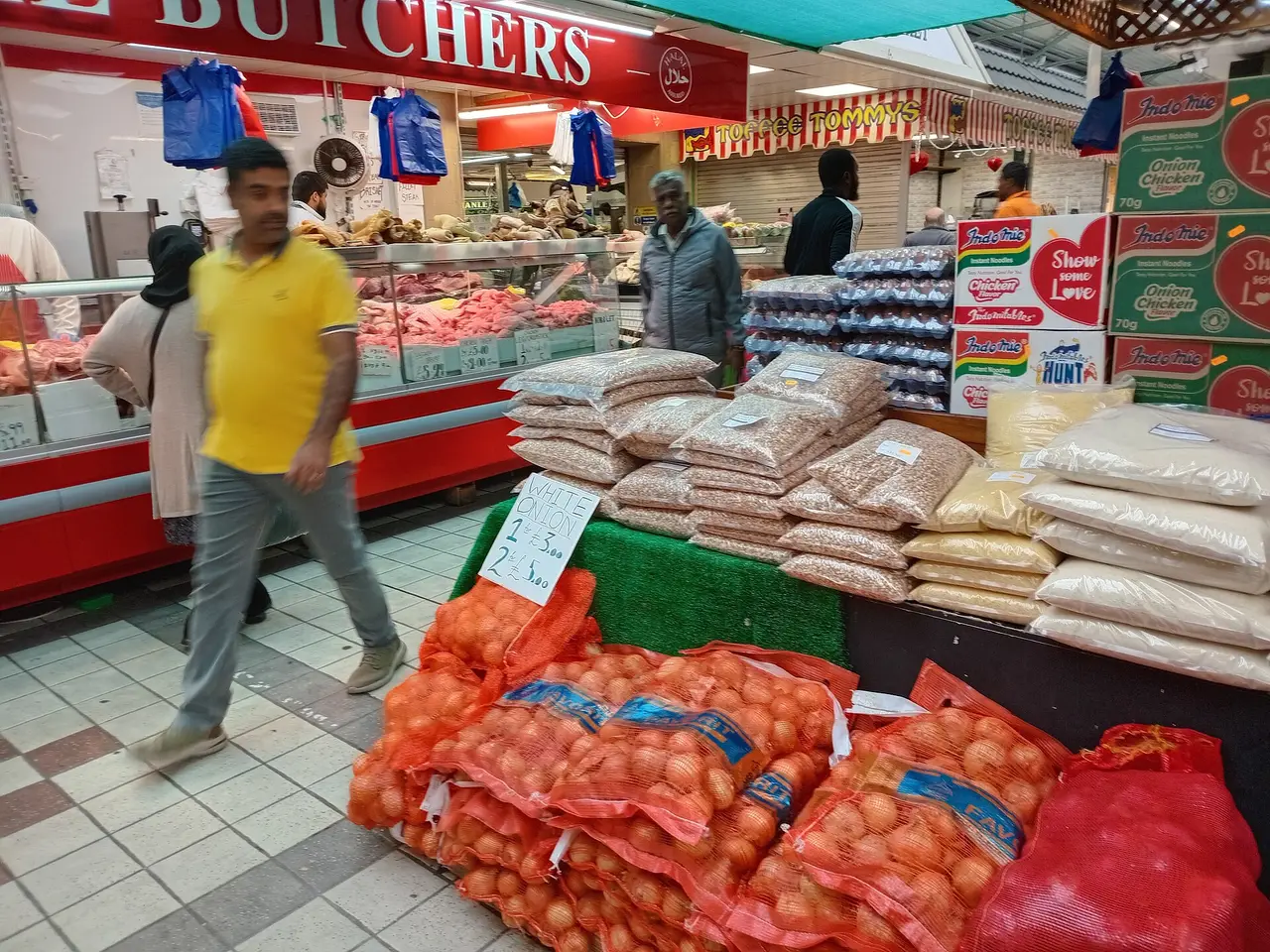 Butcher's counter and sacks of onions in an indoor market