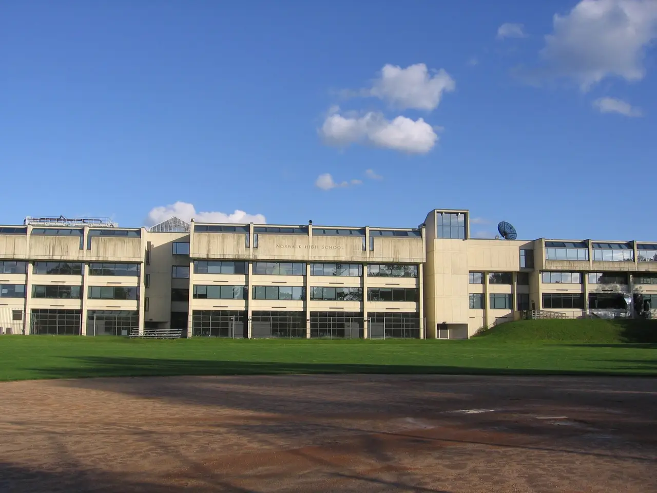 School building with several storeys seen across a lawn