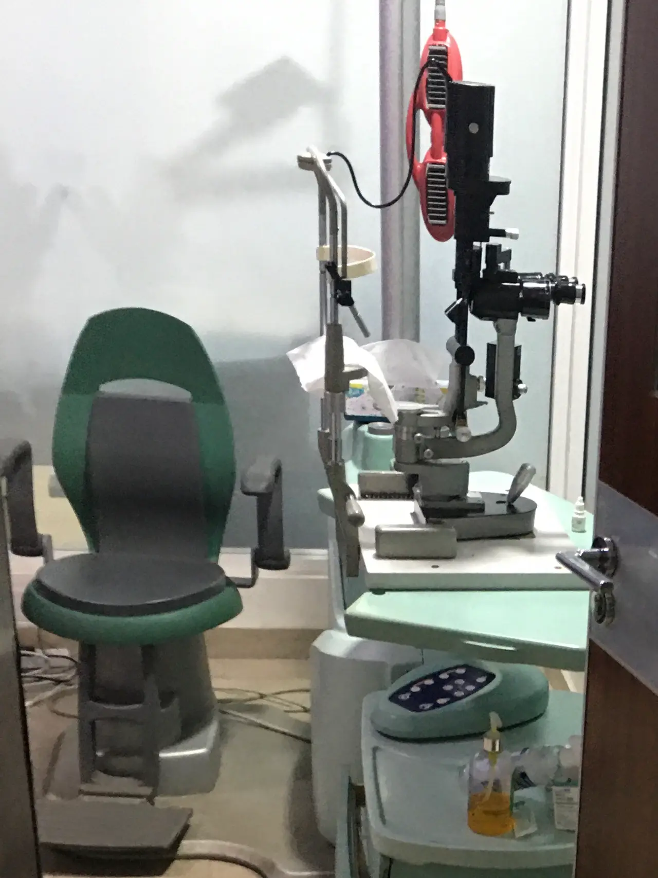 Eye test equipment and a green chair in a hospital room