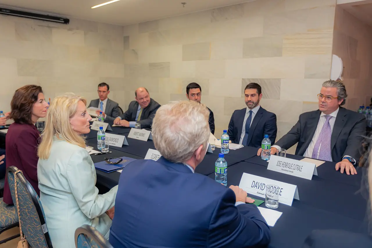 People seated around a long conference table at a business meeting