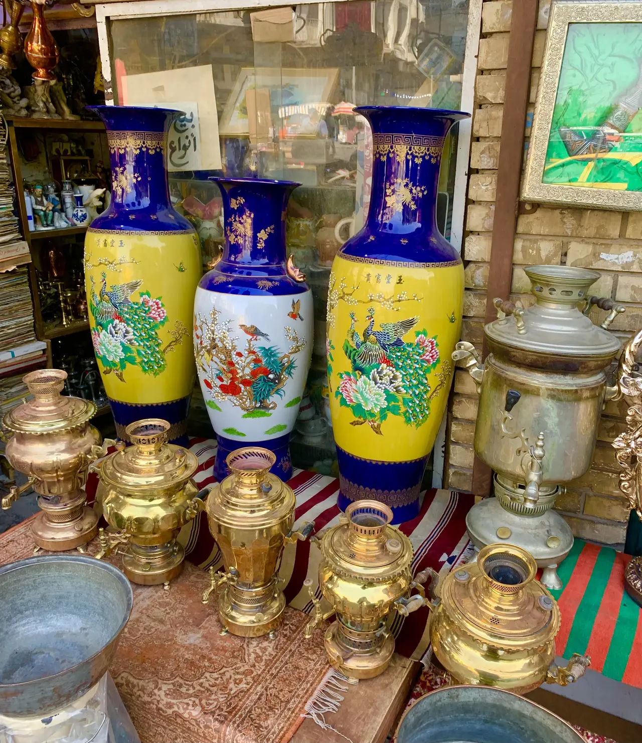 Blue and yellow vases and brass samovars on a market stall