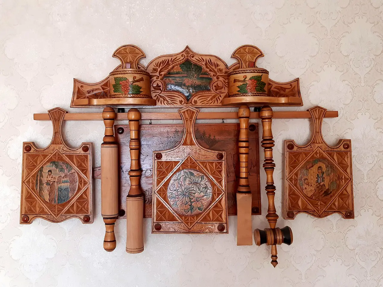 Painted wooden kitchen tools hung together on a wall rack