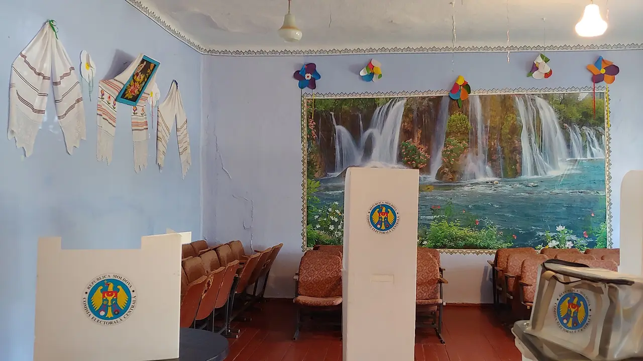 Two voting booths and a ballot box inside a polling station room