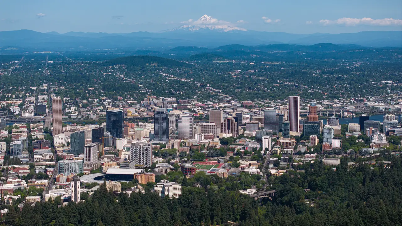 Aerial view of Portland city towers with a distant snowy mountain