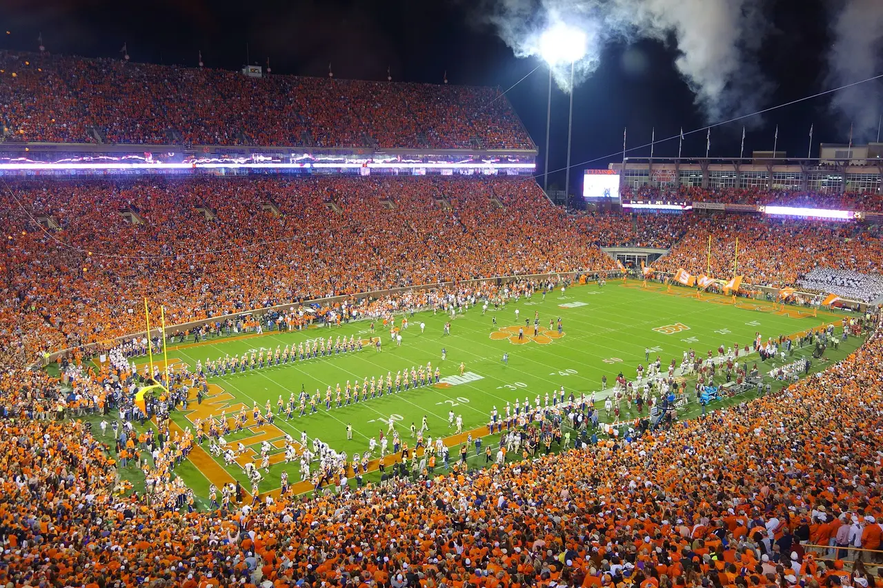 A floodlit American football stadium packed with fans in orange