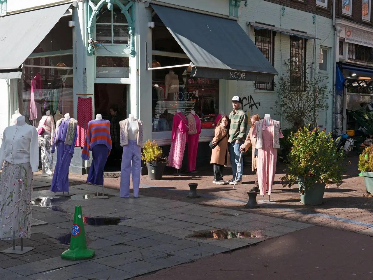 Mannequins in coloured clothes outside a corner clothing shop