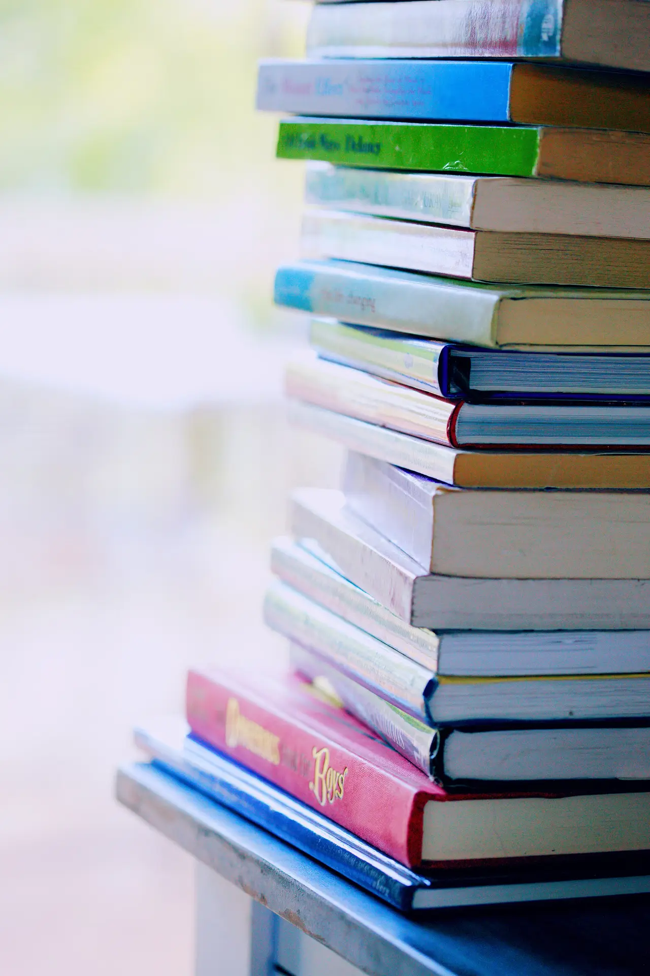 A tall stack of colourful books on a table