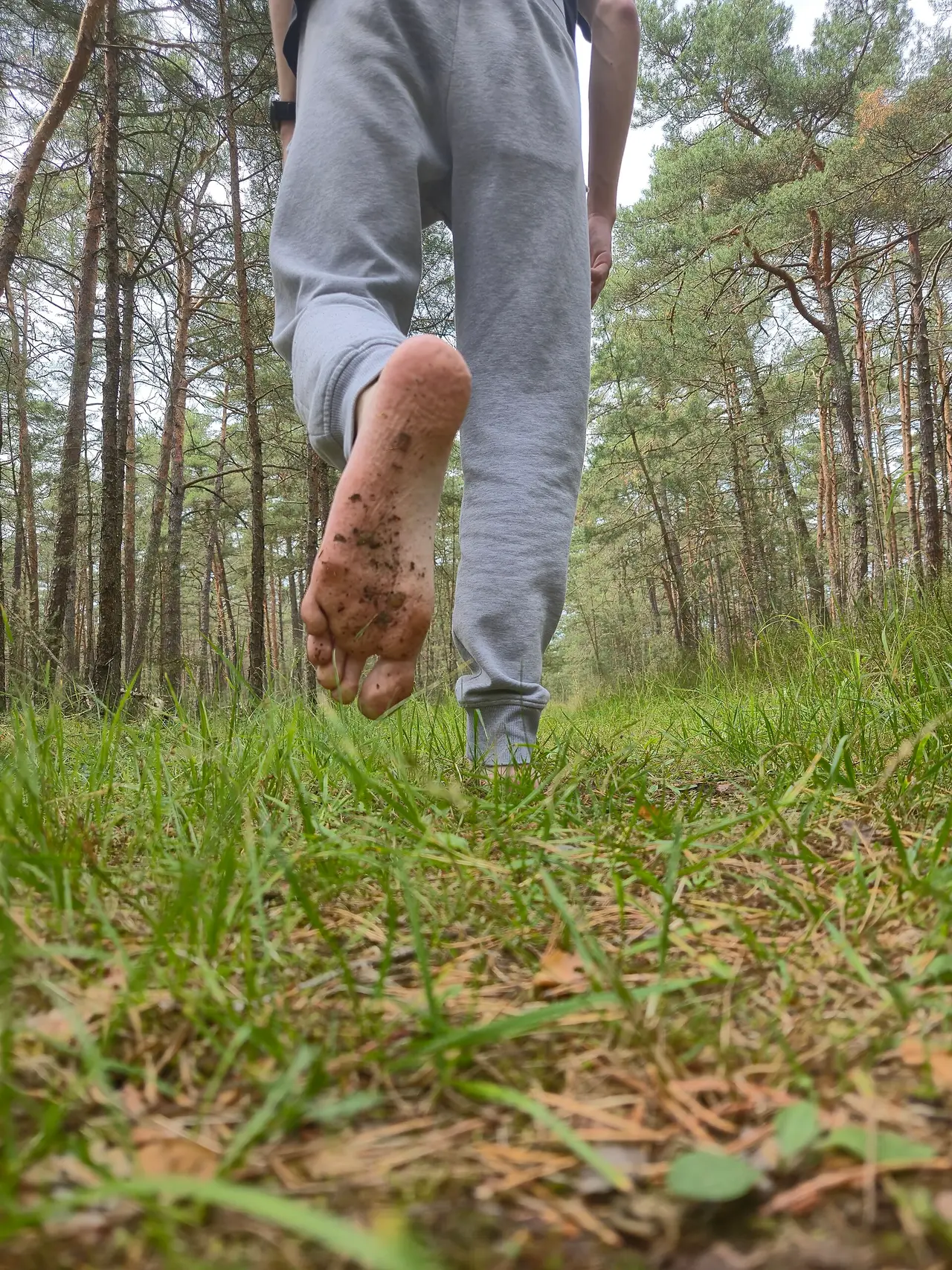 Bare feet and legs walking along a woodland path