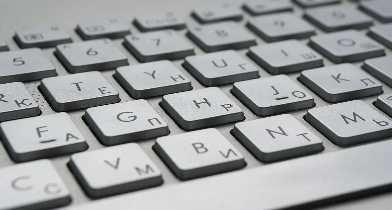 Close view of white keyboard keys with Latin and Cyrillic letters