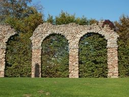 green trees at ancient ruins of roman aqueduct, germany, schwetzingen