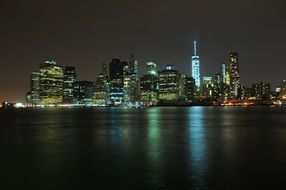 night skyline of new york city with reflection on water, usa, manhattan