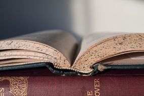 open vintage book lying on closed one