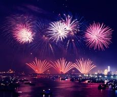 gorgeous fireworks at night sky above city at water