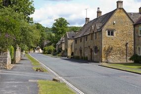 idyllic village street with old yellow limestone buildings, uk, england, cotswold