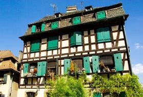 medieval building with green shutters on windows, france, strasbourg