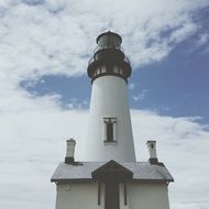 lighthouse and chimneys at cloudy sky