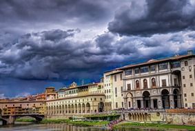 arno river under stormy clouds, italy, florence