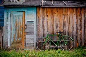 green bicycle at old wooden shed