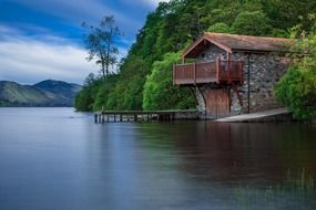 cottage with pier on mountain lake, uk, scotland