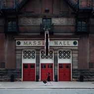 woman walking on pavement at entrance to massey hall, canada, toronto