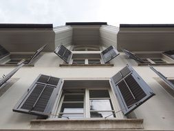 windows with open shutters on facade, bottom view