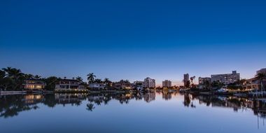 evening skyline of tropical citiy with reflection on water