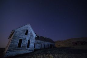 old house stands on a hill at night